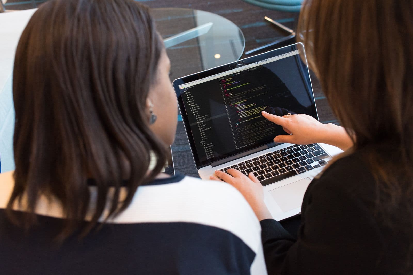 Developer building server infrastructure on a laptop with code on screen