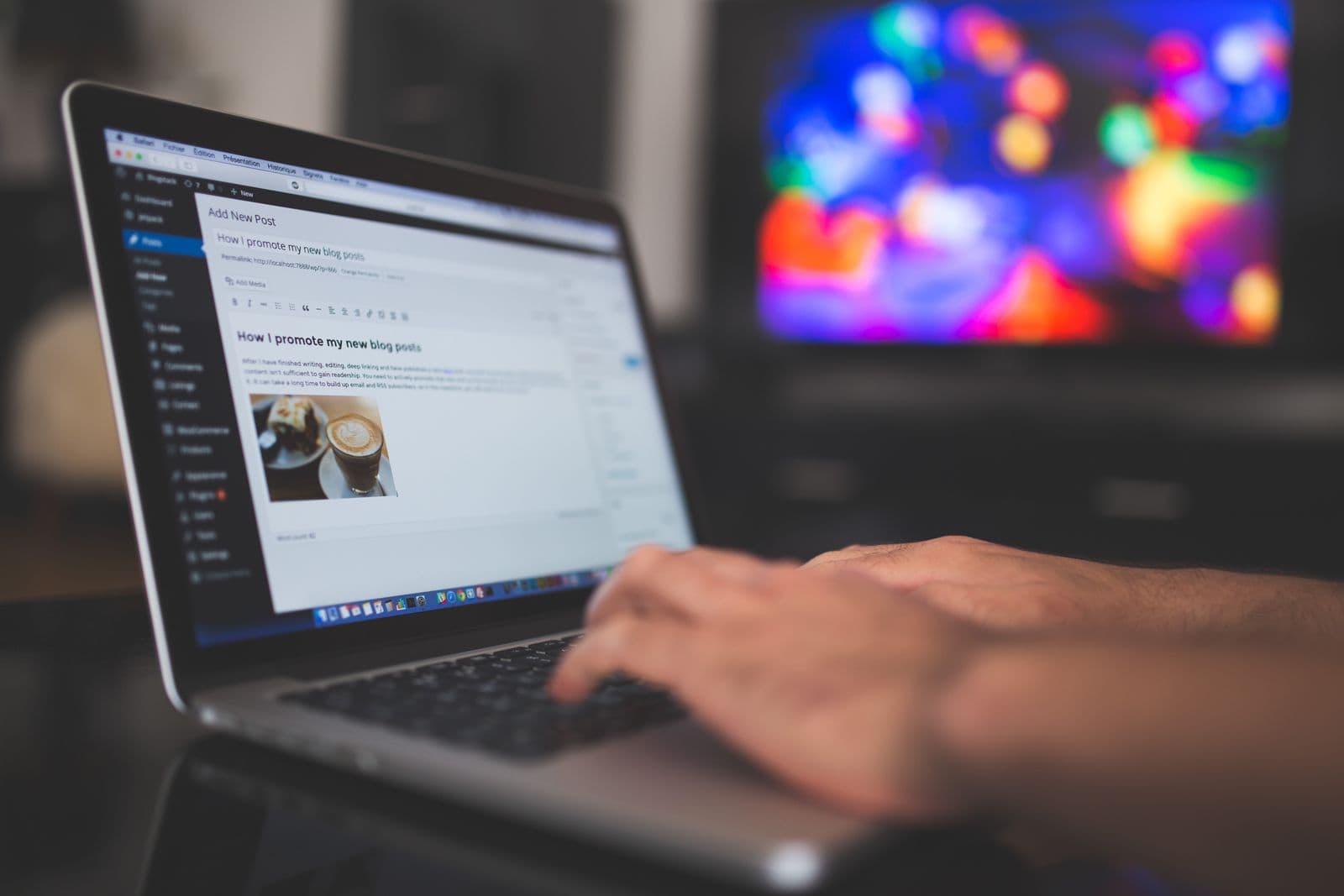 Hands typing on a laptop at a desk workspace