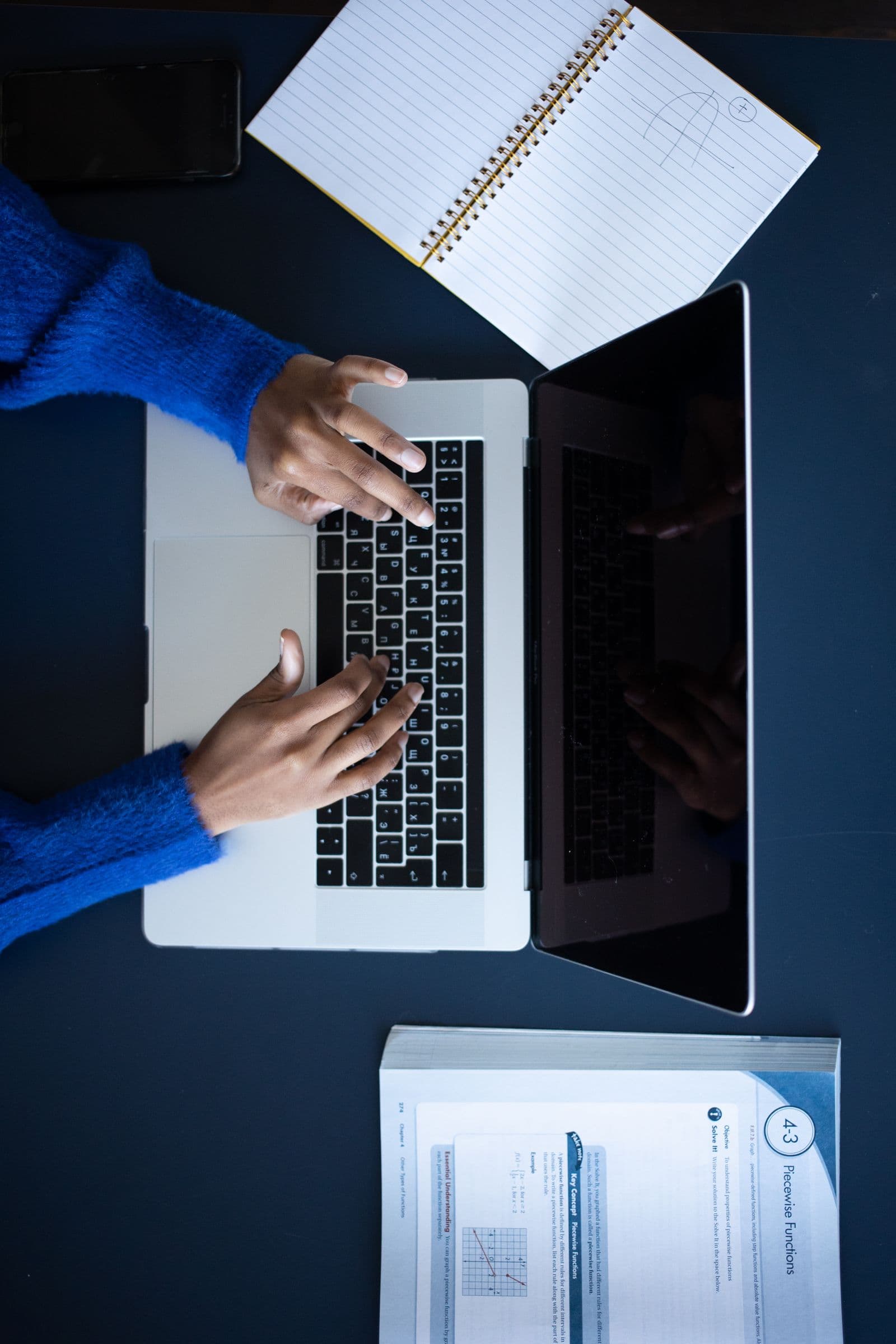 Person typing on a laptop at a focused workspace